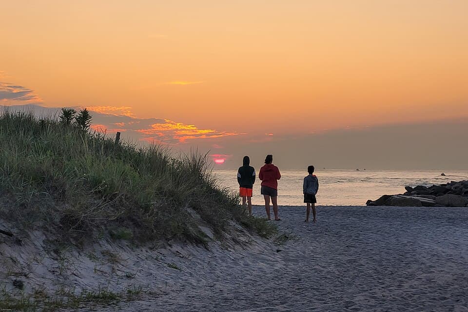 People watching the sunrise over a Delaware beach