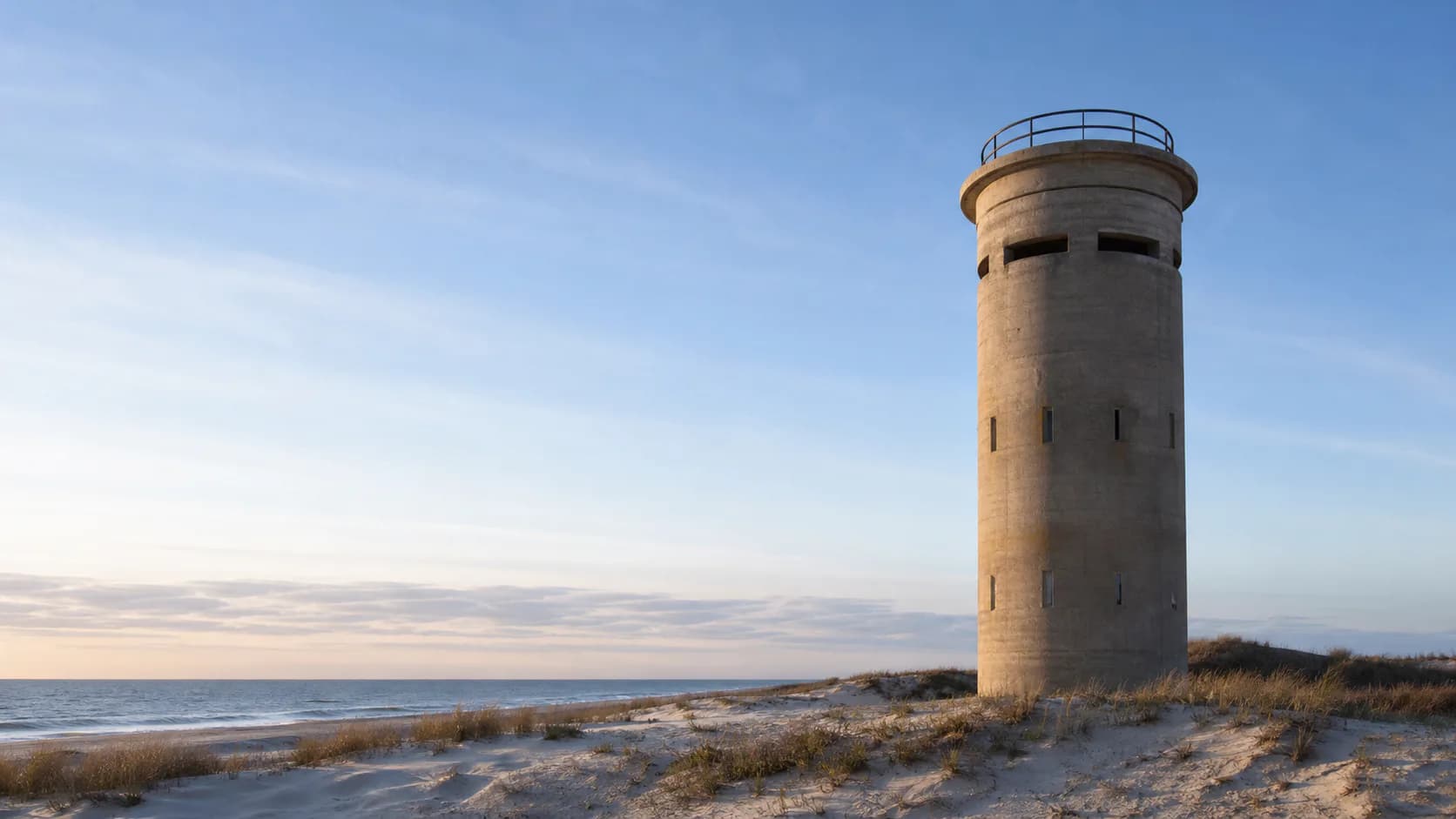 A World War II fire-control tower rising above Delaware coastal dunes
