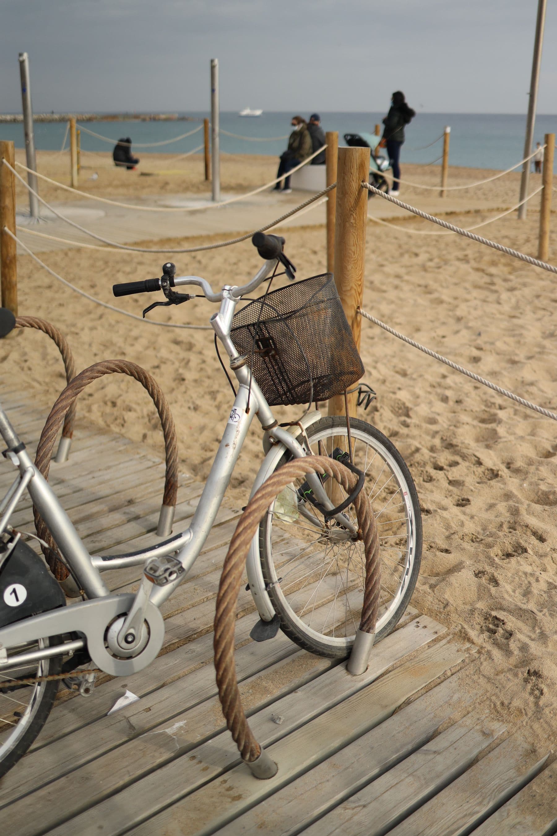 Bicycle with a basket parked on a sandy beach access path