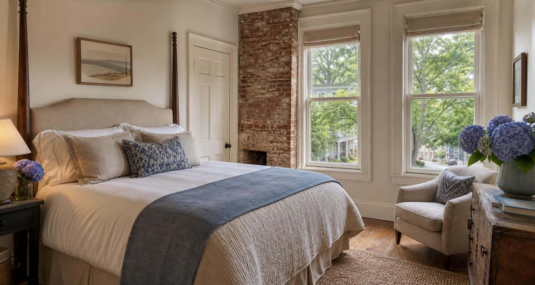 A serene historic Lewes inn room with linen bedding, brick details and hydrangeas