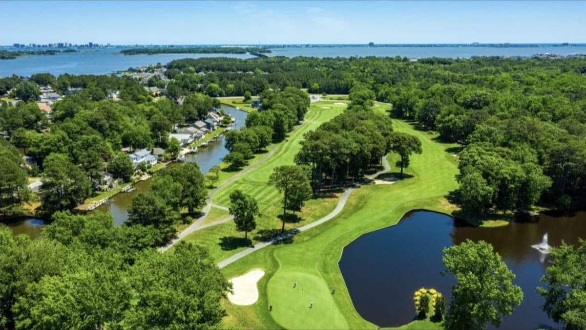 Aerial view of a golf course, waterways, and pine trees in Ocean Pines